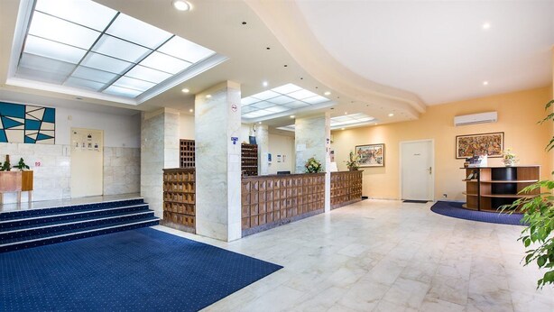 A spacious lobby with a blue carpet, marble flooring, a reception desk, and a staircase leading to upper floors. - Adriatica Rooms (Dubrovnik)