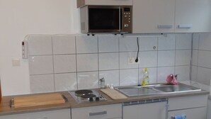 A compact kitchen with a microwave, sink, and a small countertop.