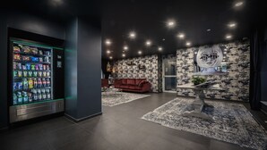A modern lobby with a vending machine, a red sofa, and a patterned wall.