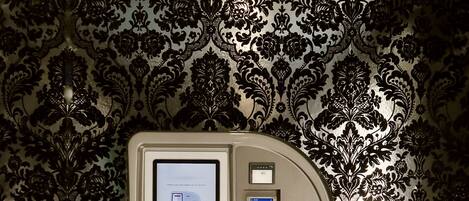 A control panel with a screen and buttons, set against a patterned wallpaper.