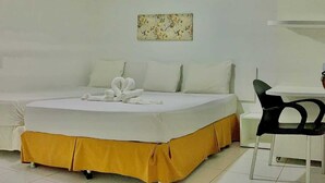 A hotel room with a bed, a desk, and a chair.