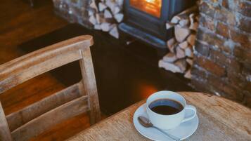 Una silla y una mesa de madera con una taza de café y una cuchara.