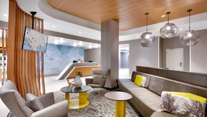 A modern lobby with a reception desk, seating area, and a map display. - SpringHill Suites by Marriott Salt Lake City Sugar House (Salt Lake City)