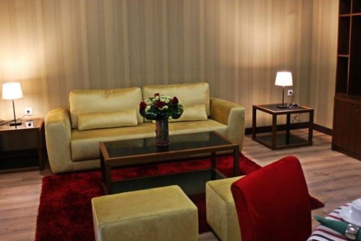 Ein Wohnzimmer mit einer Couch, einem Couchtisch, einem Fernseher und zwei Lampen.
