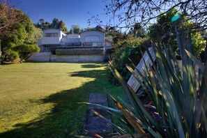 A modern two-story house with a well-maintained lawn and a stone pathway leading to the entrance.