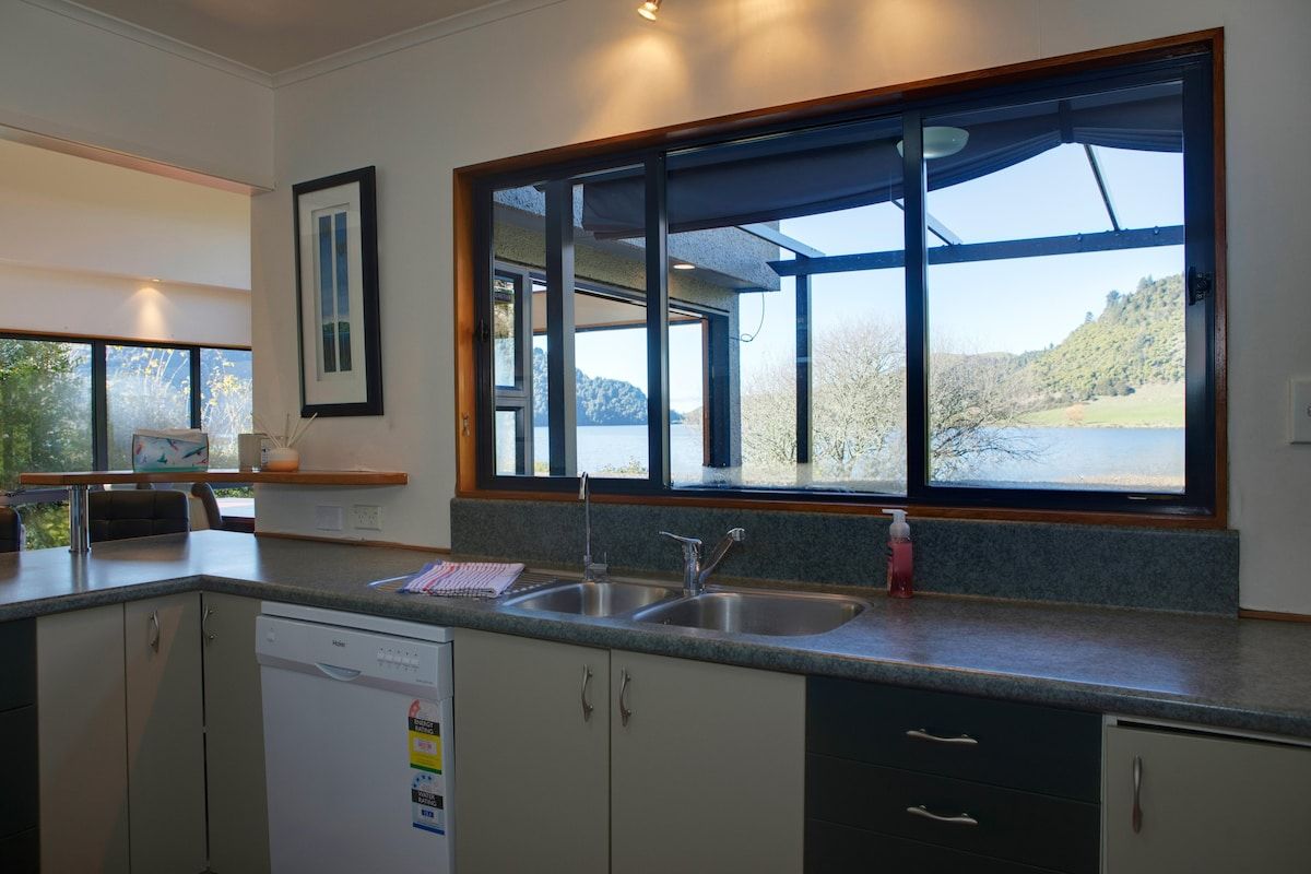 A modern kitchen with a large window, a dishwasher, and a sink.