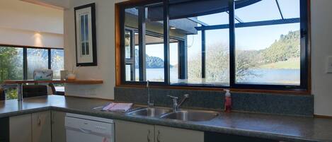 A modern kitchen with a large window, a dishwasher, and a sink.