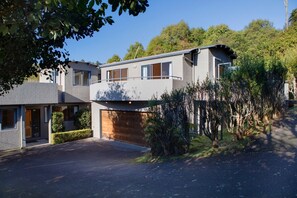 A modern two-story house with a garage, a driveway, and a well-maintained garden.