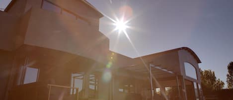 Un edificio moderno con un interior iluminado por el sol y un espacio exterior cubierto.