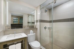 Une salle de bain moderne avec une douche à parois de verre, un lavabo et des toilettes.