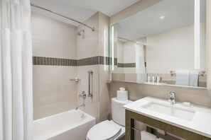 Enjoy a clean and minimalist bathroom with a separate shower and toilet area, featuring a large mirror, handheld showerhead, and bidet.