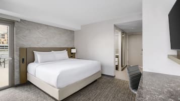 Ein Hotelzimmer mit einem großen Bett, einem Schreibtisch und einem Fernseher.