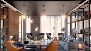 Una sala de estar moderna con un sofá, dos sillones de cuero, una mesa de centro y una estantería.