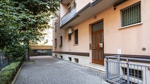 Une ruelle étroite pavée, bordée d’un immeuble doté d’une porte en bois et d’un balcon.