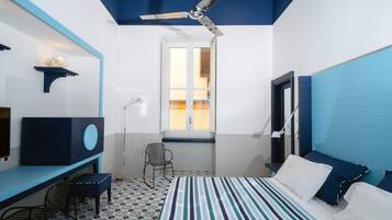 Un dormitorio con cama, escritorio, silla y ventilador de techo.