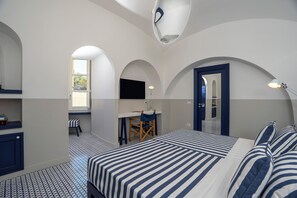 Relax in this serene bedroom with a large bed, desk, and cozy seating area.