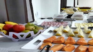 Una mesa de buffet con diversas frutas y fiambres.