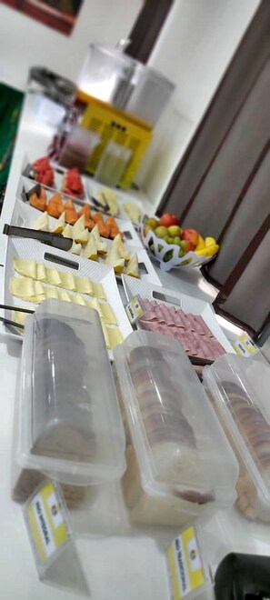 A buffet table with various food items including fruits, cheeses, and packaged meats. - Jardins Premium (Ipojuca)