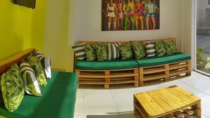 Una habitación con un sofá verde, una mesa de centro de madera y un cuadro en la pared.