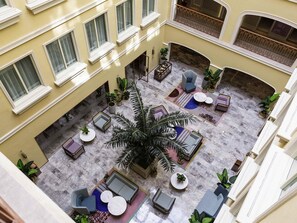A multi-level hotel lobby with a central seating area, multiple windows, and a large plant. - Mercure Taiyuan E Tech (Taiyuan)