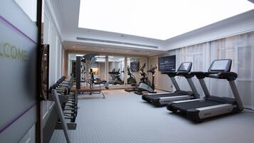 A modern gym with treadmills, stationary bikes, and weight machines.