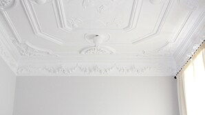 Ein Hotelzimmer mit einem großen Bett, zwei Nachttischlampen und einer dekorativen Decke.
