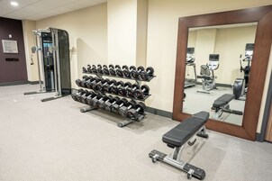A gym with dumbbells, a bench, and exercise equipment.