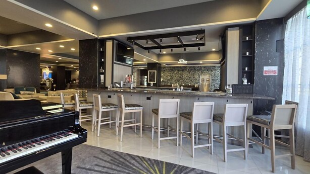 Een moderne woonkamer met een piano, een bar en eettafels.