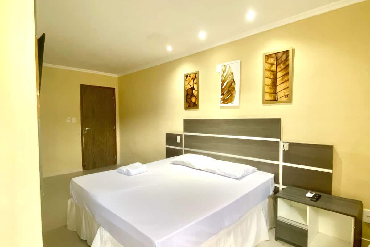 A modern bedroom with a large bed, a bedside table, and a headboard.