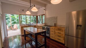 Una cucina moderna con isola centrale, mobili in legno e frigorifero in acciaio inossidabile.