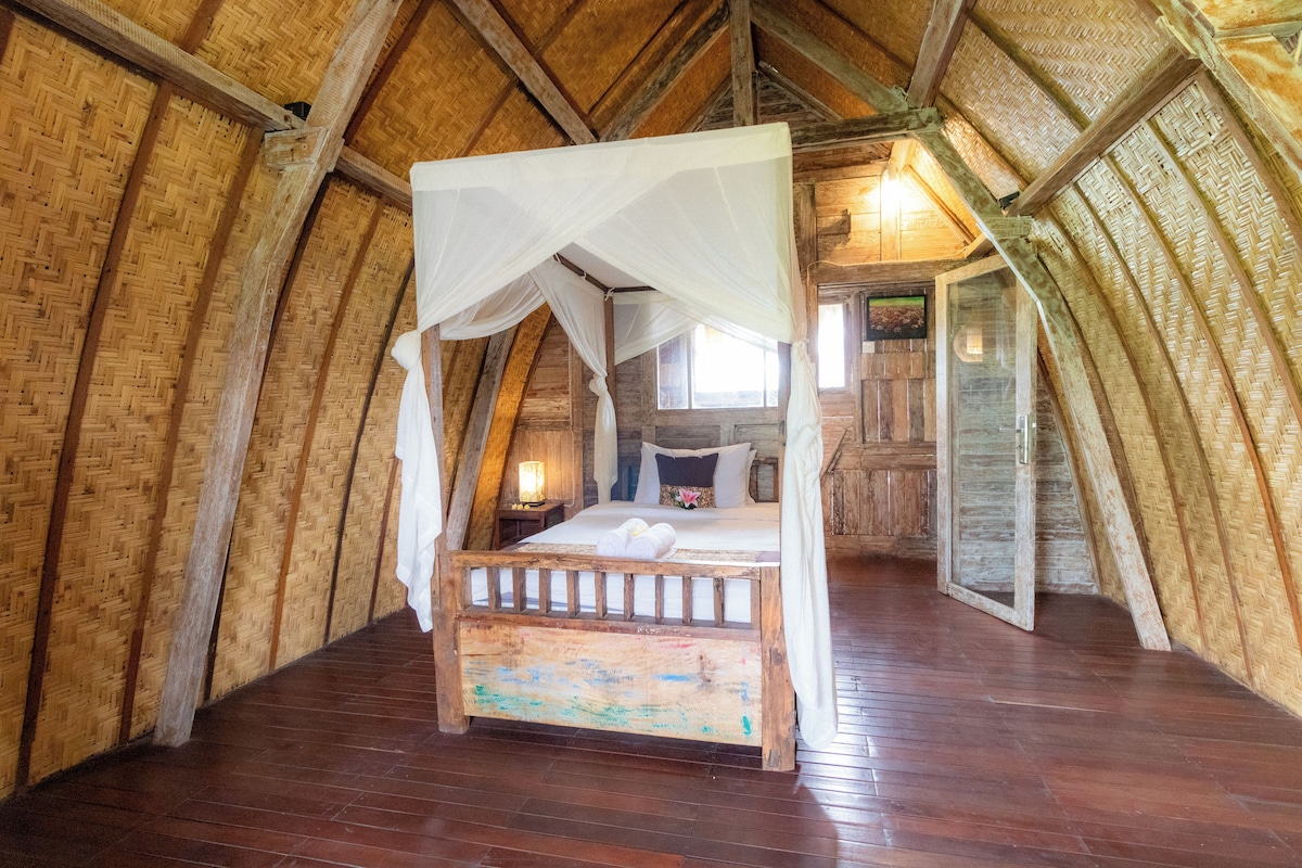 Une pièce rustique avec un décor en bois, comprenant un lit à baldaquin, un plancher en bois et un plafond en pente.