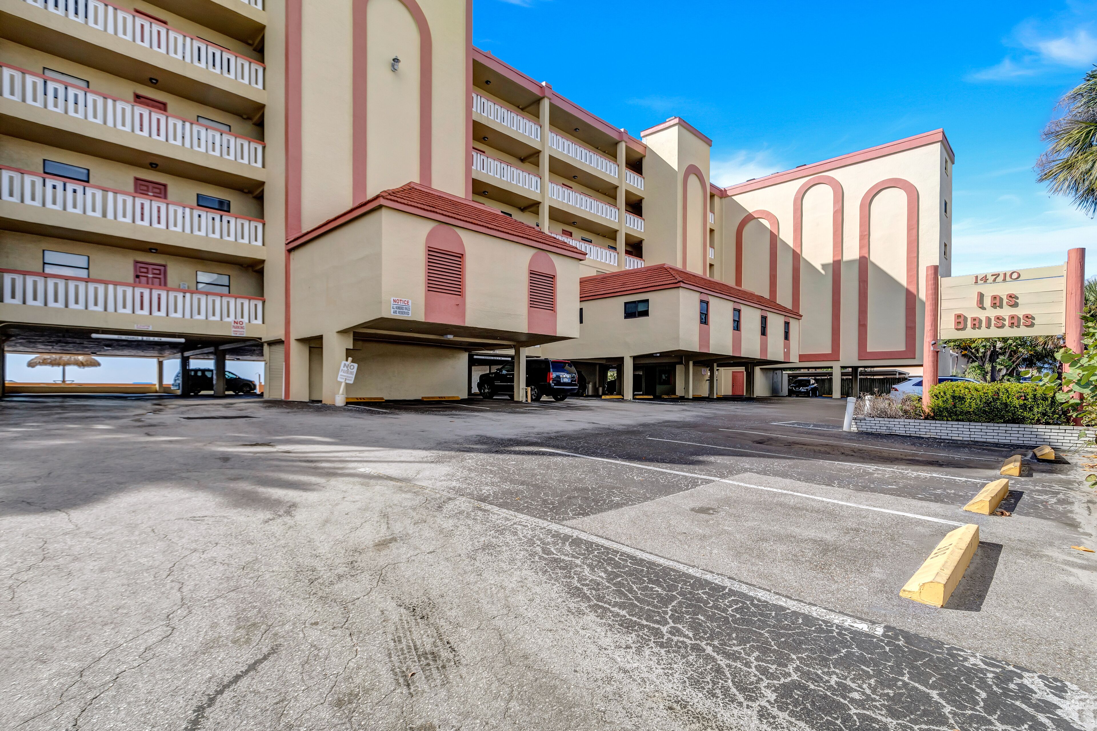 Un hotel a più piani con un'area di parcheggio antistante.
