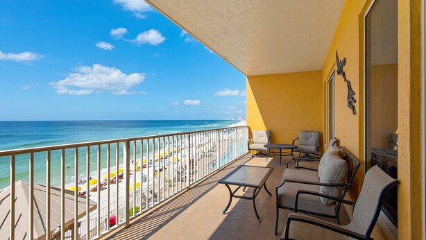 A balcony with a view of the beach and ocean. There are chairs and a table on the balcony. - Treasure Island 0305 (Panama City Beach)