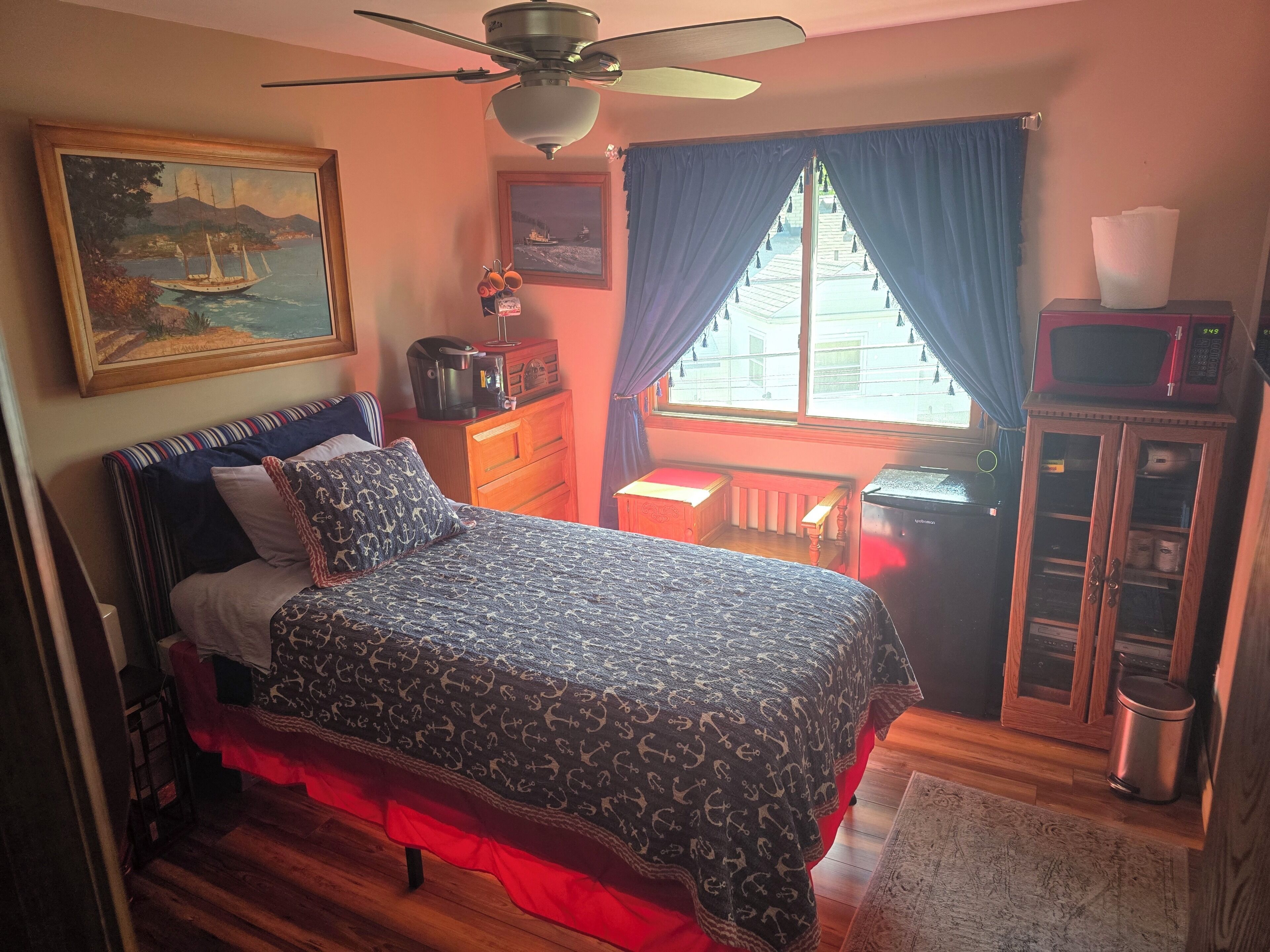 Un dormitorio con cama, cómoda, microondas y armario.