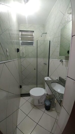 A bathroom with a toilet, sink, and shower area. - Sunset Atlantica (Rio de Janeiro)