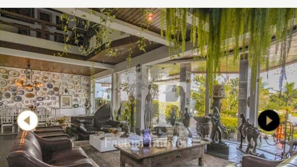 Ein geräumiges Wohnzimmer mit Ledersofas, einem Couchtisch und einer mit Tellern dekorierten Wand.