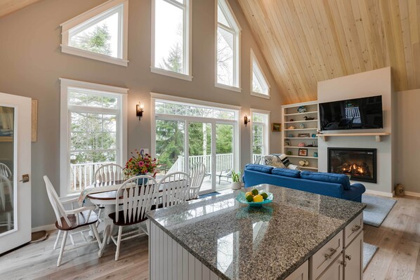 Relax in this inviting space with a central island, fireplace, and dining area.