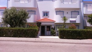 A multi-story residential building with balconies, a tiled roof, and a 'For Sale' sign. - Exquisite Poolside Apt at the fabulous Oasis Parque. Unlimited WiFi IPTV etc (Portimão)