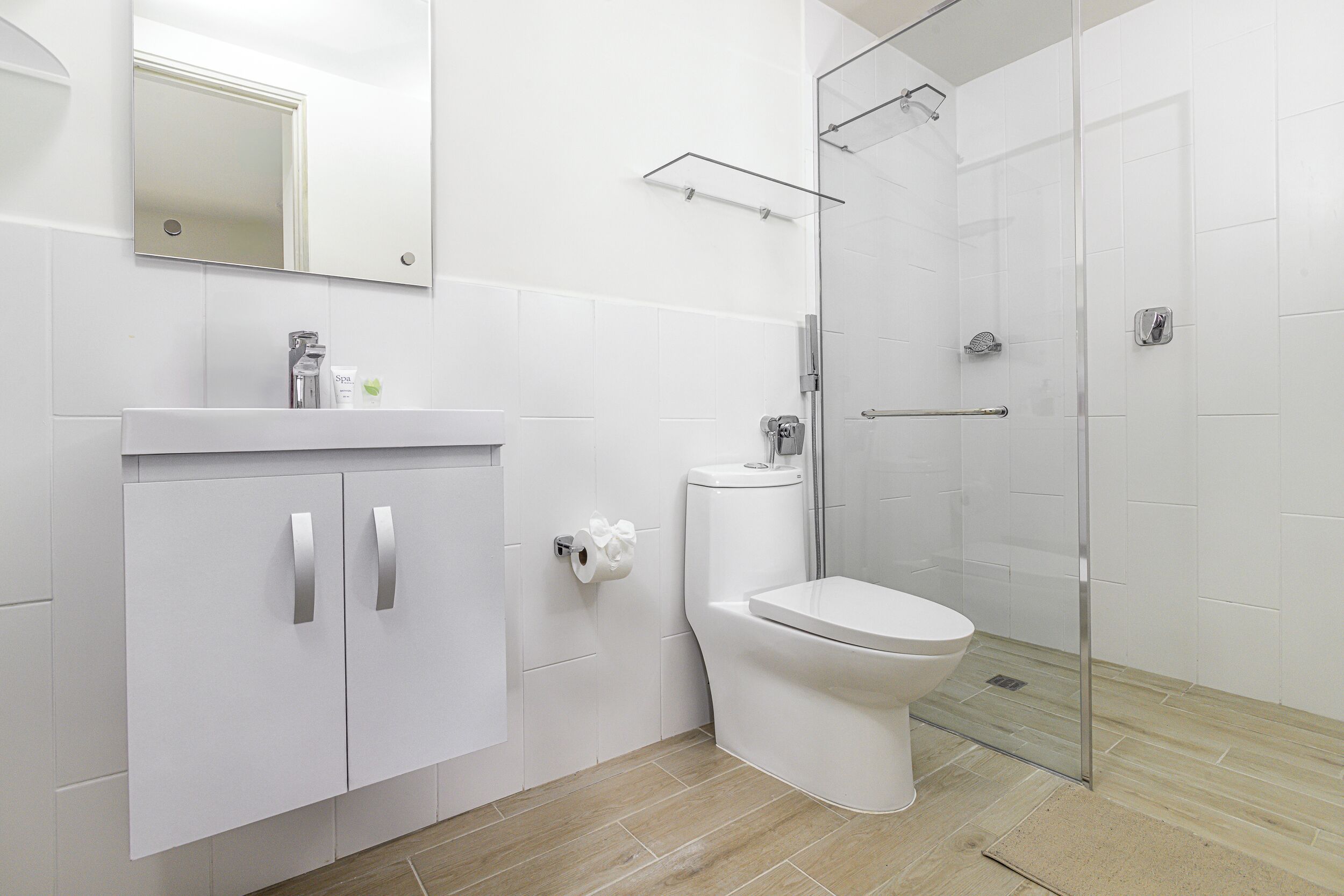 A modern bathroom with a toilet, sink, and shower.