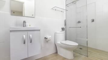 A modern bathroom with a toilet, sink, and shower.