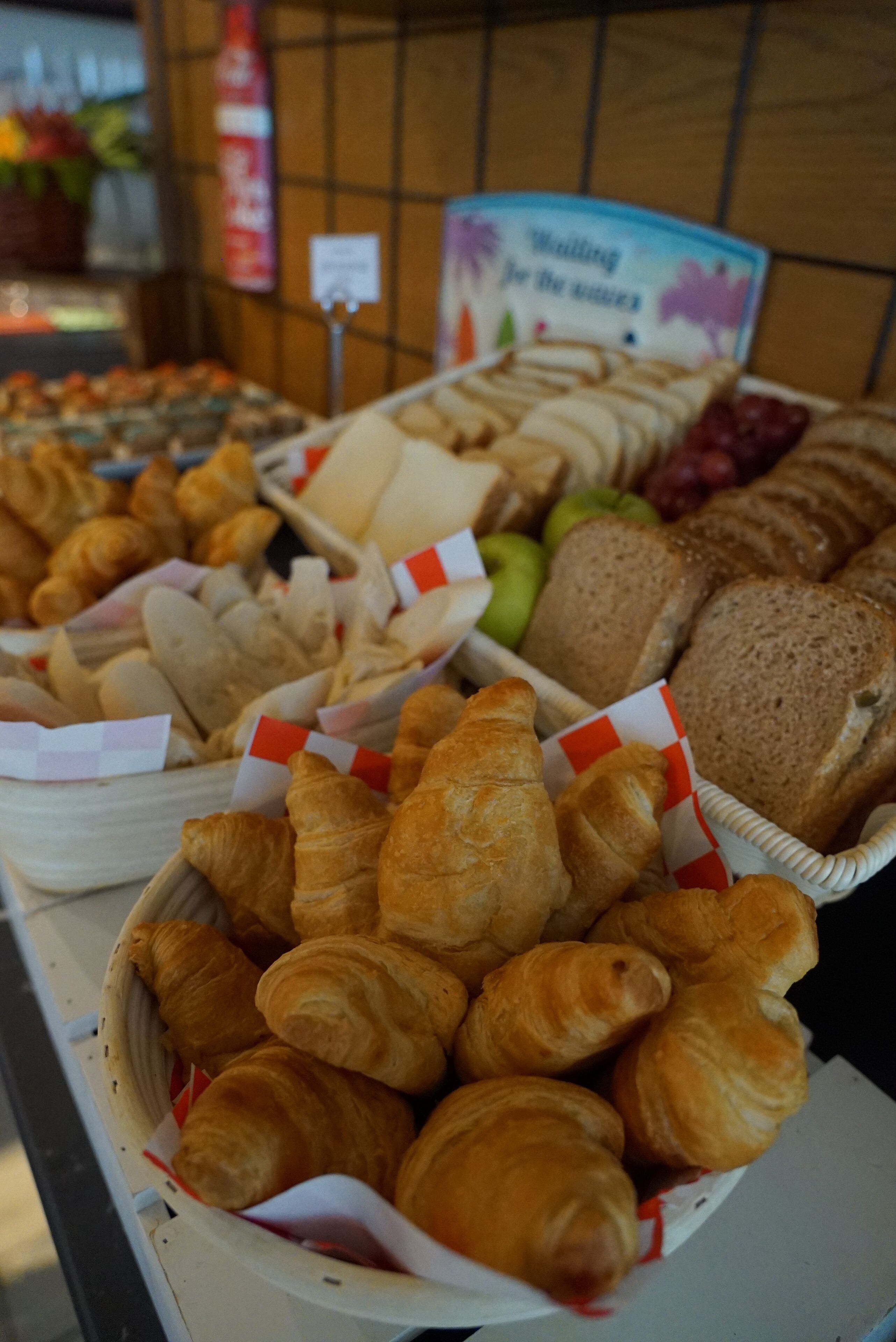 Eine Auswahl an Gebäck und Brot, darunter Croissants und Baguettes, präsentiert auf einer Theke.