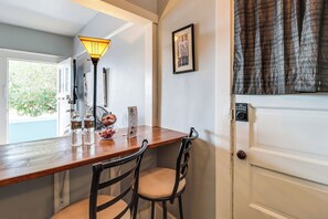 Ein Holztisch mit Stühlen, einer Lampe und einer Tür mit Zahlenschloss.