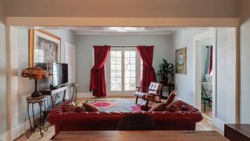 A living room with a red sofa, a television, and a wooden coffee table.