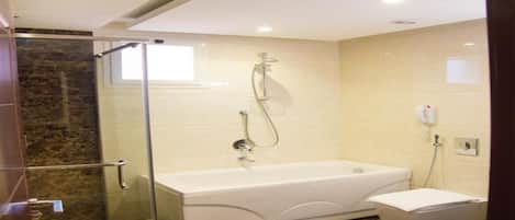 A modern bathroom with a glass-enclosed shower, a freestanding bathtub, and a separate toilet area.