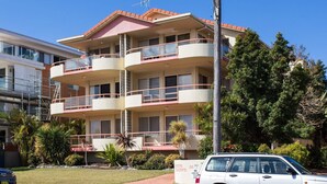 A multi-story building with balconies, a car parked in front, and a sign indicating '36' and 'Junk Mail'. - Haven Waters 6 - On the Lake! (Forster)
