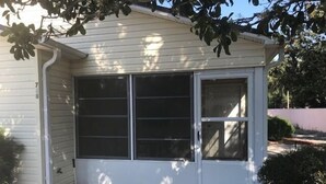 Ein eingeschossiges Haus mit einem großen Fenster zur Straße und einem kleineren Seitenfenster.
