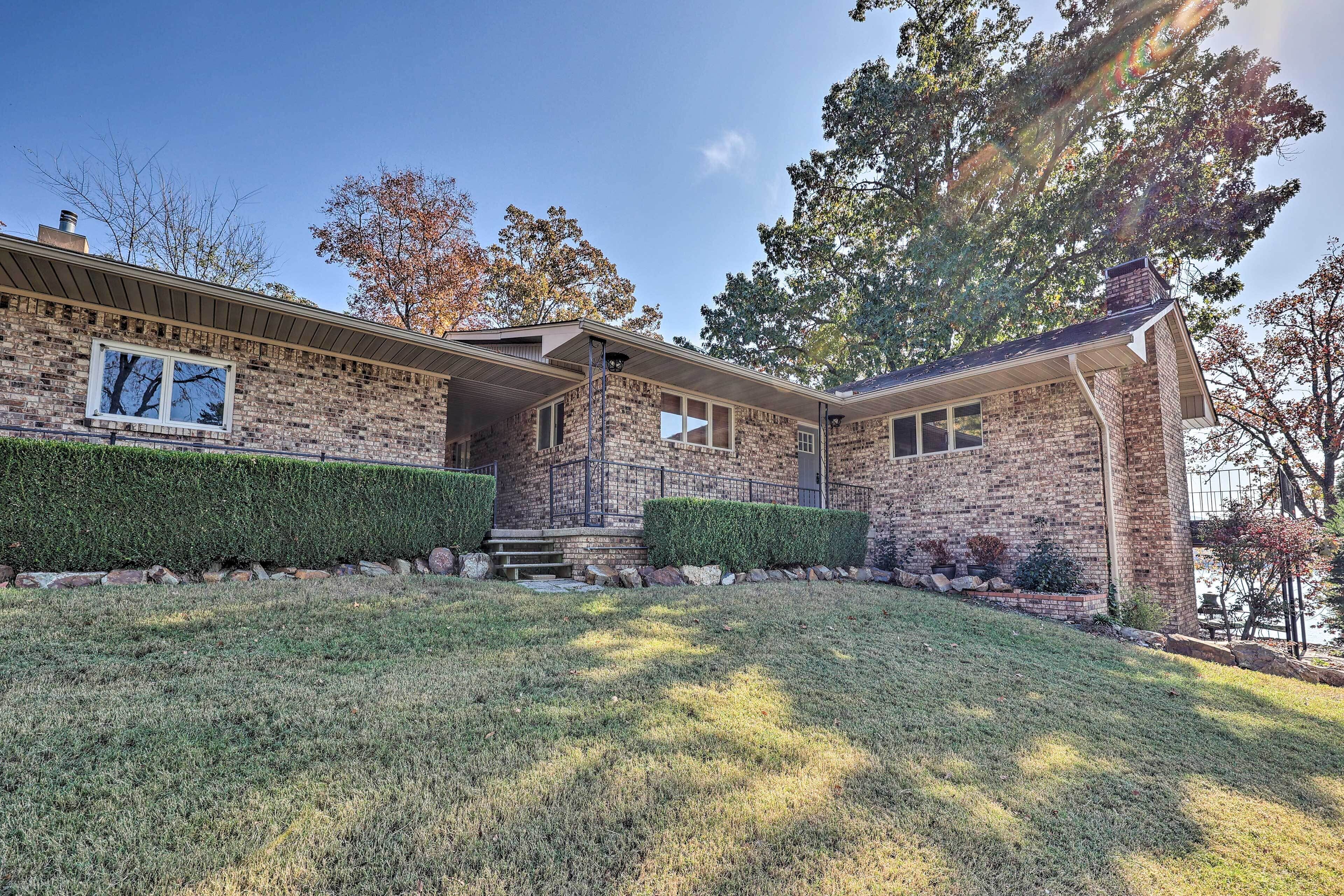 A two-story house with a brick exterior, a front porch, and a well-maintained lawn.