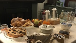 Un bufé de desayuno con bollería, frutas y salsas.