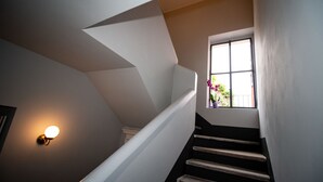 Una escalera con barandilla y una ventana con maceta.