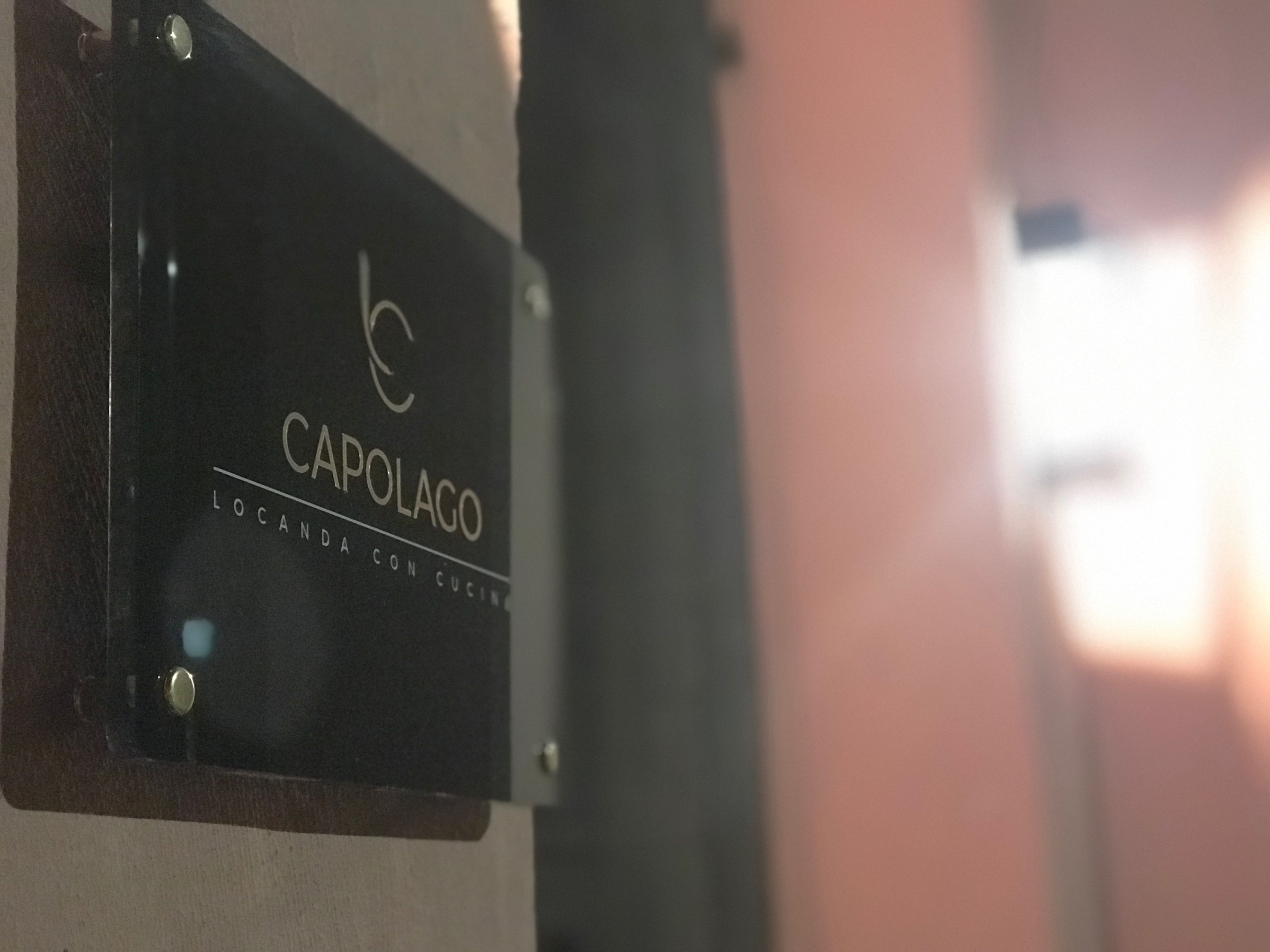 A sign with the text "CAPOLAGO LOCANDA CON CUIN."